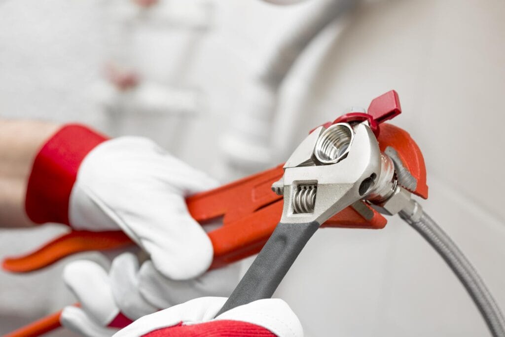 Plumber holding pipe wrenches for an emergency repair in Casselberry