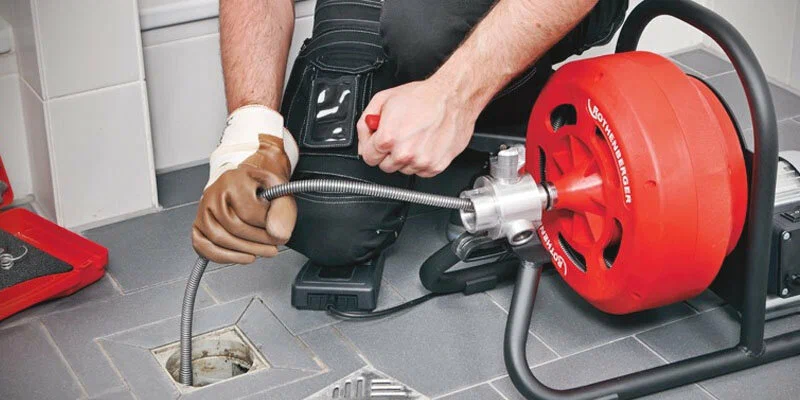 Plumber using a drain-cleaning machine in Casselberry