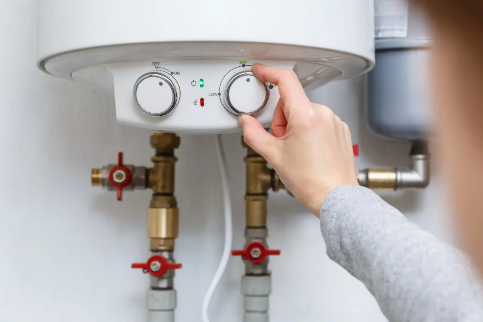 Homeowner adjusting the temperature controls on a water heater in Casselberry
